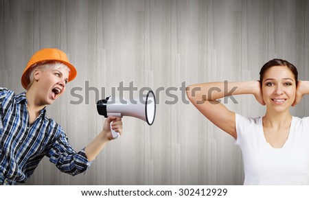 Young furious woman screaming agressively in megaphone