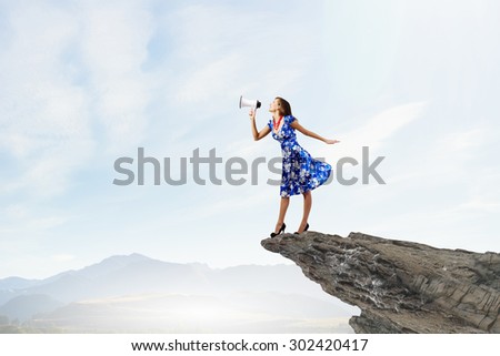 Young woman making some announcement in trumpet