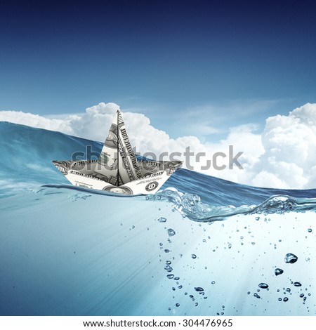 Ship made of dollar banknote floating in water