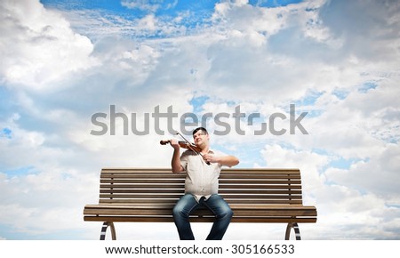 Fat man sitting on bench and playing violin
