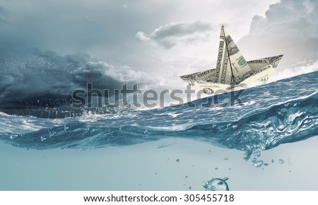 Ship made of dollar banknote floating in water