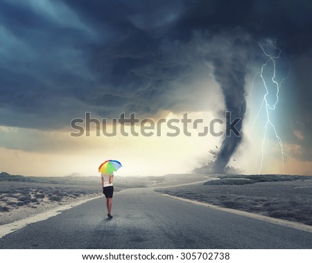 Young pretty businesswoman with rainbow colorful umbrella walking in storm
