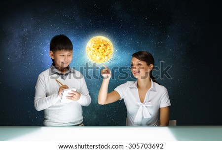 Cute boy of school age and teacher exploring space system