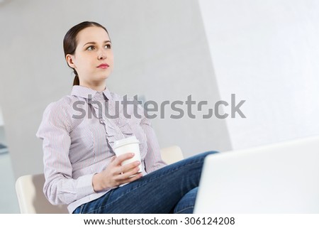 Young pretty girl in casual sitting with coffee in hands