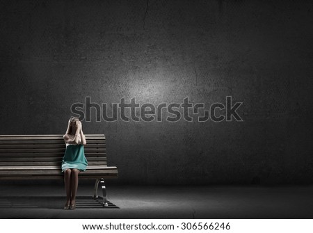 Young woman sitting on bench closing eyes with palms