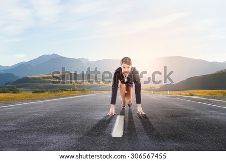 Young determined businesswoman standing in start position