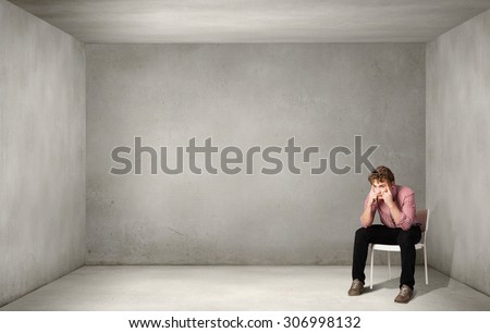 Depressed man sitting on a chair all alone