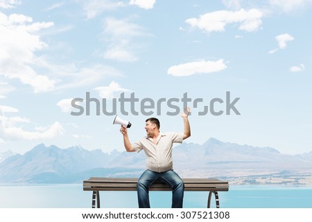 Fat man sitting on bench and screaming in megaphone