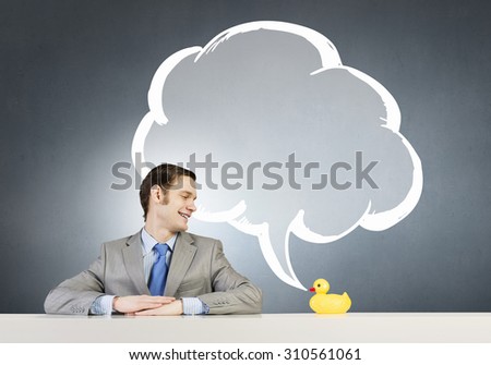 Funny businessman with yellow rubber duck toy