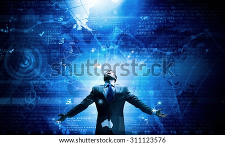 Businessman with hands spread apart standing in light coming from above
