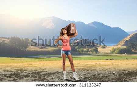 Young retro woman with her vintage baggage on shoulder