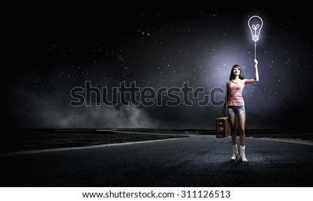 Young retro woman with balloon and her vintage baggage in hand