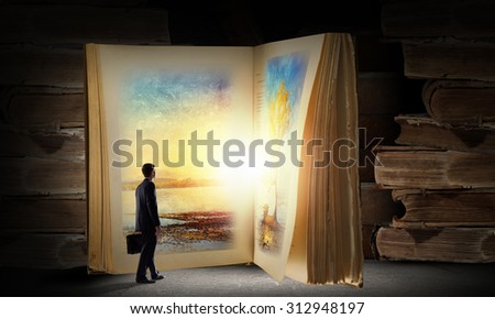 Big old opened book and miniature of businessman
