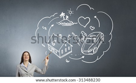 Young attractive businesswoman with paint brush and business sketches on wall