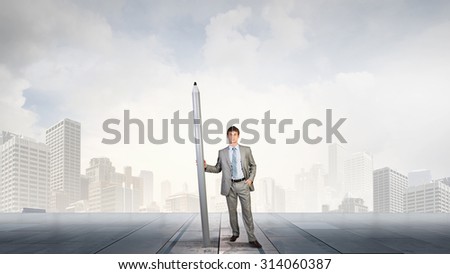 Young man architecture designer with huge pencil