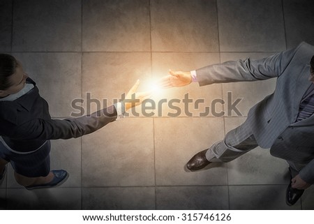 Top view of a businessman and woman shaking hands in office lobby
