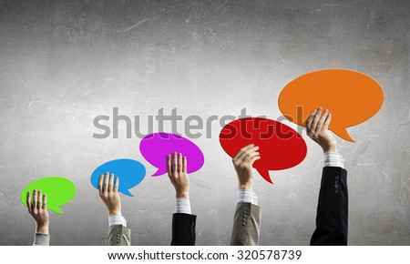 Group of business people holding chat cards in raised hands