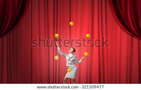 Young businesswoman in cap on stage juggling with balls