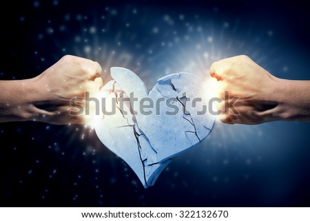 Close up of human hand breaking stone heart