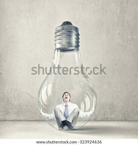 Screaming businessman trapped inside of light bulb