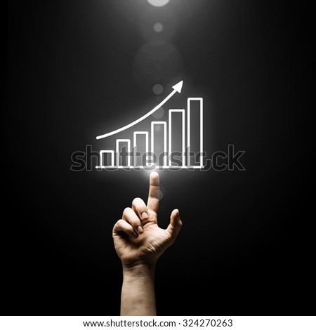 Human hand pointing with finger at growing graph