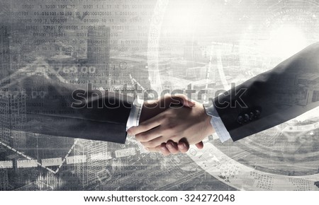 Close up of business handshake on digital background