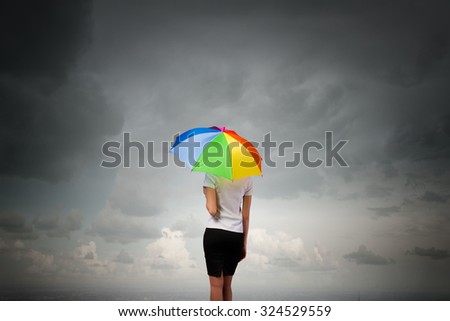 Back view of businesswoman in suit with colorful umbrella