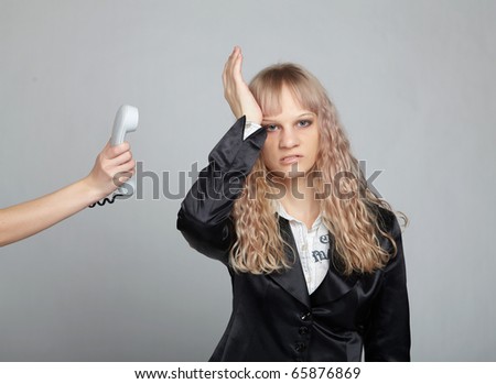 Funny business woman in a black suit with a gray background is angry phone call