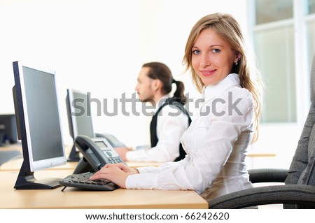 A young girl in his office at his workplace works at the computer