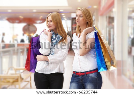 Two young beautiful girls are engaged in shopping in a store