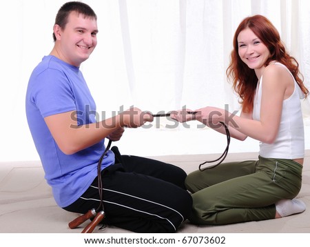 The couple engaged in sports together. Tug of a rope.