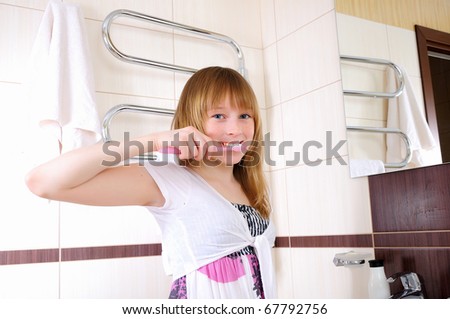 A young girl waking up early in the morning, brushing his teeth in his bathroom