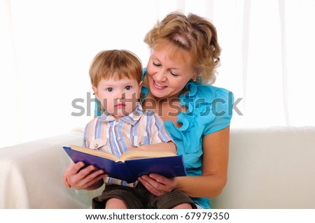 Grandmother and grandson reading a book together. Symbol of the family.