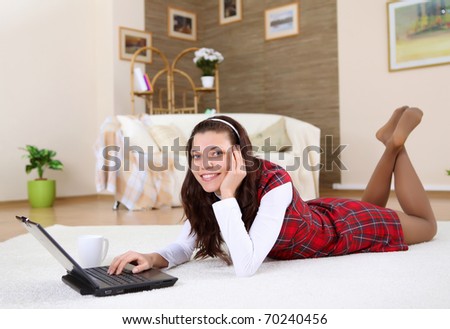 a young girl with a lap top at home on the floor of a living room