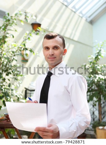 young business man working with documents in garden