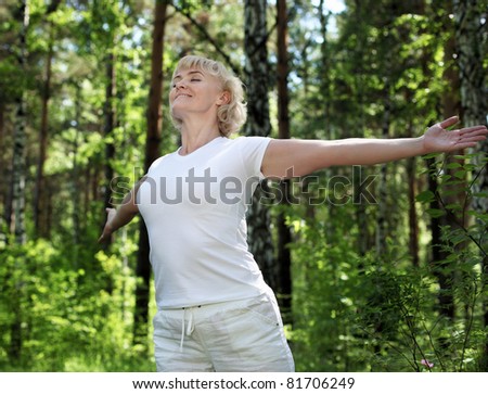 An elderly woman practices yoga in nature. The symbol of healthy lifestyle