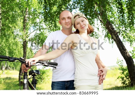 Young couple on the bikes in the summer park