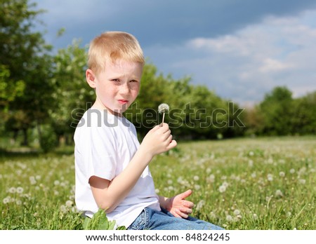 red-hair boy with dandelion in the park