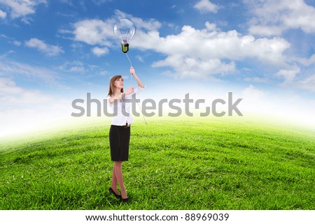 Young businesswoman outdoor with a bulb as a symbol of creative thinking