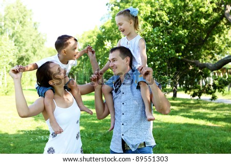 Young happy family with two children in the summer park