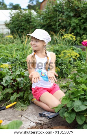 Little happy girl gardening in the summer