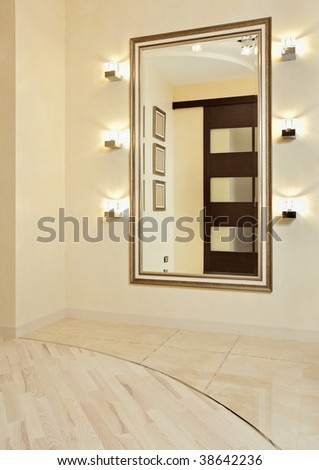 Mirror in golden frame in beige colored anteroom