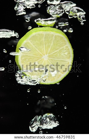 Lime (lemon)  falling in water on black with air bubbles