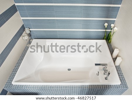 Modern bathroom in blue and gray tones with rectangular bath tub