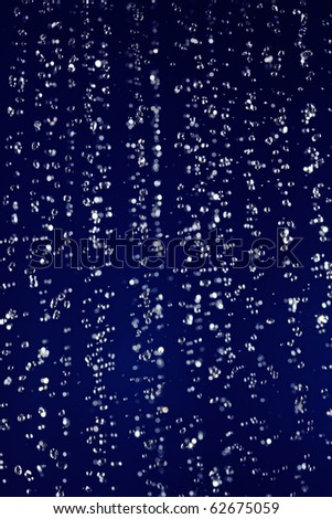 Stopped motion water drops background on deep blue