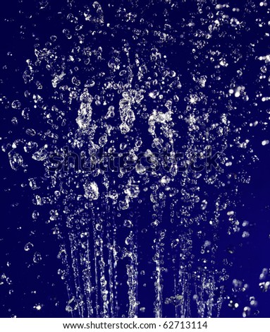 Stopped motion water drops background on deep blue