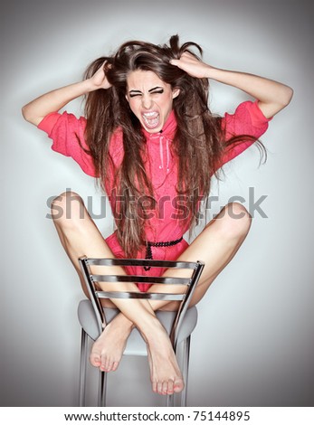 Screaming aggressive emotion woman in pink blouse with long hairs, ring flash studio portrait on white