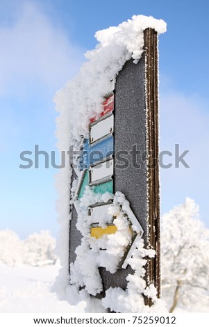 Signpost for tourism in the winter covered by snow and ice