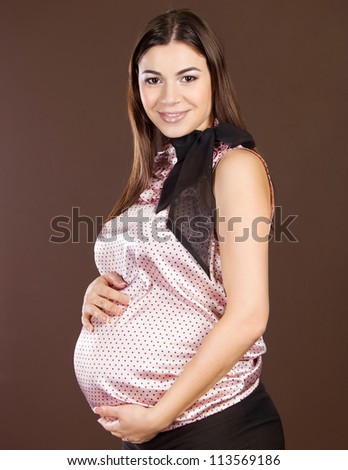 Happy beautiful pregnant woman touching her belly