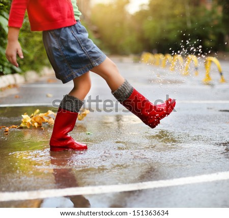 Child Wearing Red Rain Boots Jumping Into A Puddle. Close Up Stock ...